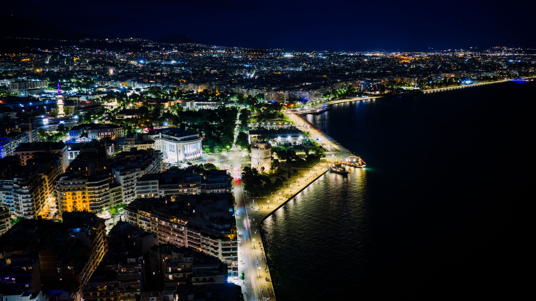 Aerial night view of Thessaloniki's illuminated waterfront in Greece